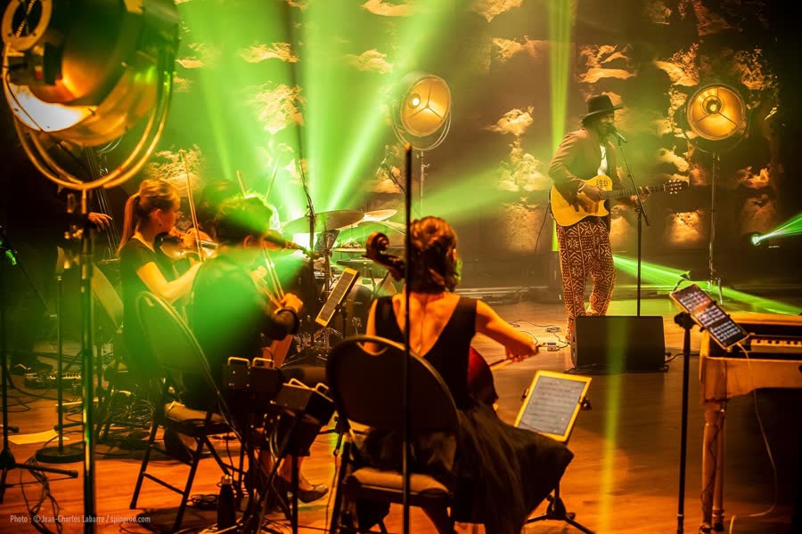 Violoncelliste sous une nappe de faisceaux verts